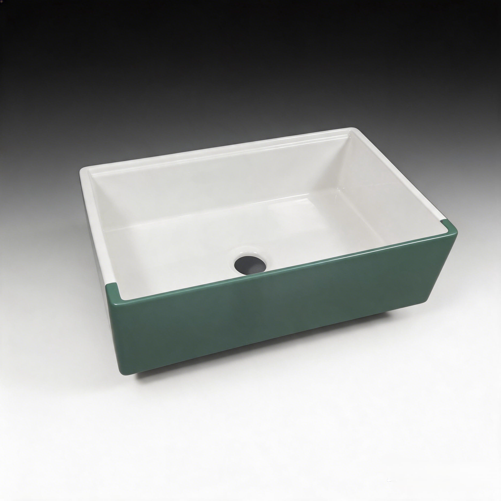 Fireclay farmhouse sink with matte green apron and white interior, single bowl workstation format